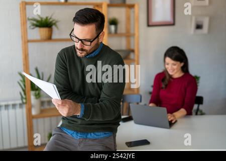 Happy businesspeople laughing while collaborating on a new project in an office. Stock Photo