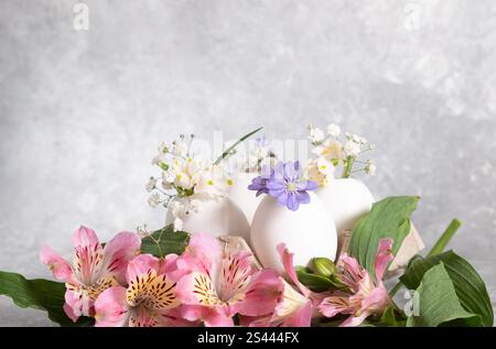Floral Easter arrangement on a blue background. packaging for eggs and spring flowers in an eggshell. DIY, blur and selective focus. Stock Photo