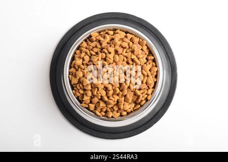 Cat food in bowl isolated on white background. Brown cat kibble. Flat lay, Top view Stock Photo