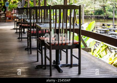Wooden chairs and table on the backyard in tropical cafe near lake with beautiful view in island Borneo, Malaysia, close up Stock Photo