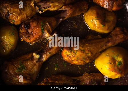 Roasted chicken legs with potatoes and herbs Stock Photo