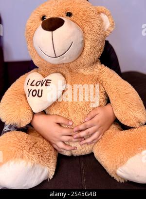 Happy little boy hugging teddy bear with drip in hand smiling . Stock Photo