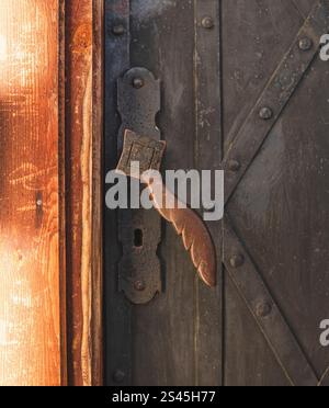 A close-up of the handle on an old metal door Stock Photo