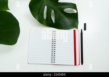 open red notebook with pencil. school notebook on white background, spiral notepad on table Stock Photo