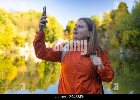 Close up shot of worried 30s woman hiker using a app on her smartphone.  Stock Photo