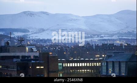 Stunning view of Edinburgh city and snow-covered mountains from Edinburgh Castle's terrace, highlighting the historic charm of Scotland's capital. Stock Photo