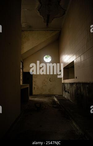 A haunting image of the interior of an abandoned building, featuring crumbling walls, exposed structures, and debris scattered across the floor. The photograph captures the essence of abandonment and decay, making it ideal for urban exploration themes, historical projects, or conceptual storytelling Stock Photo