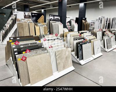 Kyiv, Ukraine - January 10, 2025: Modern showroom featuring a variety of large format tiles displayed on angled racks, showcasing different colors, te Stock Photo