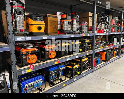 Kyiv, Ukraine - January 10, 2025: Several tools and machines, including generators and vacuum cleaners, displayed on shelves in a hardware store, show Stock Photo