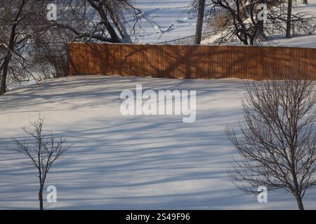 weak winter sun casts shadows on fresh snow Stock Photo