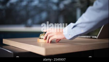 Hotel Reception. Hospitality Experience. Guest Touching Bell Stock Photo