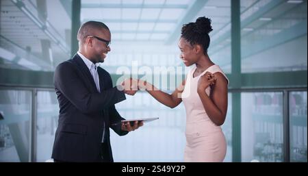 Businesspeople Discussing Standing Inside Elevator At Work Stock Photo