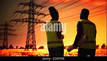 Electrician Workers Talking Near High Voltage Circuit Line Tower Stock Photo