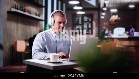 Man Using Business Laptop Online With Headset Stock Photo