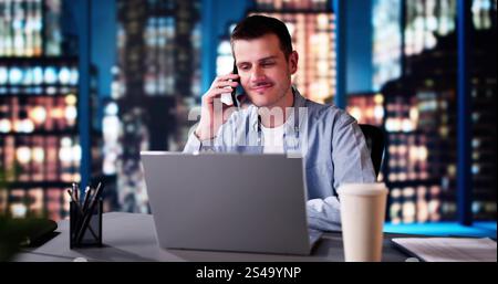 Businessman Talking With Client On Phone. Man Using Computer And Smartphone Stock Photo