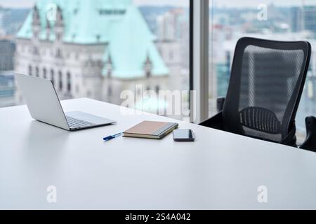 Open laptop on work table, computer at desk in skyscraper office background. Stock Photo