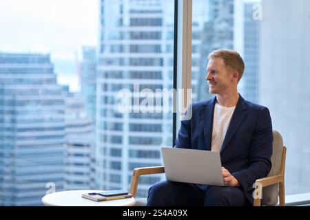 Busy happy professional businessman entrepreneur using laptop working in office. Stock Photo