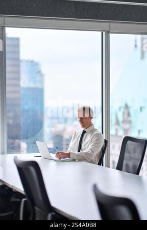 Vertical photo of busy professional business man using laptop working in office. Stock Photo