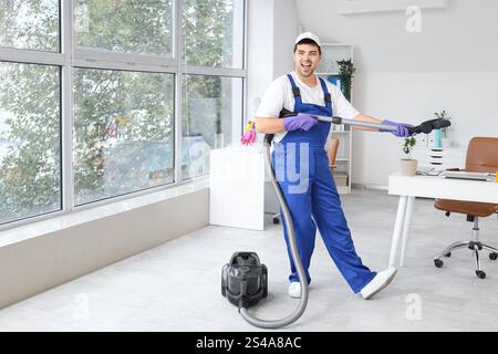 Janitor having fun while vacuuming floor in office Stock Photo