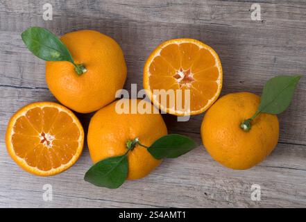 Fresh ripe tangerines with leaves on a wooden background. Close up view. Stock Photo
