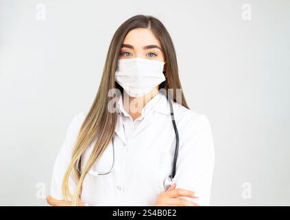 Portrait of a confident female surgeon standing with her hands clasped. Horizontal shot. Isolated on white. Stock Photo