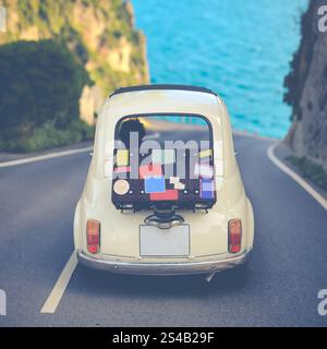 Small retro car with baggage, luggage and beach equipment on the roof ...