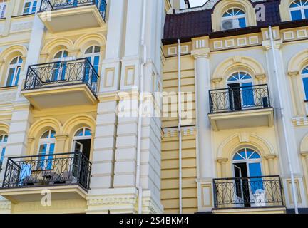 Yellow modern exterior of houses buildings. Windows open balconies facade. Bright architecture street Stock Photo