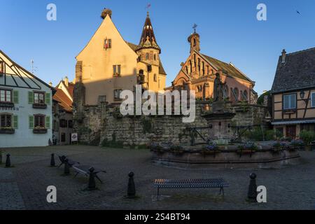 EGUISHEIM, FRANCE - MAY 30, 2019: Castle, church and fountain named Saint Leon on the central square of Eguisheim village in France with the tradition Stock Photo