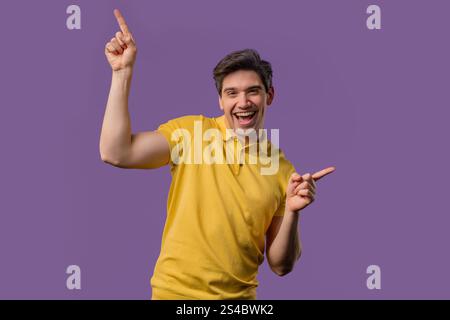 Energetic american 30s man dancing on violet background. Portrait of stylish guy in hipster shirt. High quality Stock Photo