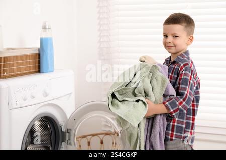 Little helper. Cute boy doing laundry at home Stock Photo