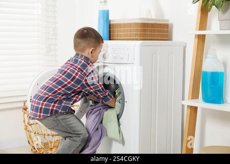 Little helper. Cute boy doing laundry at home Stock Photo