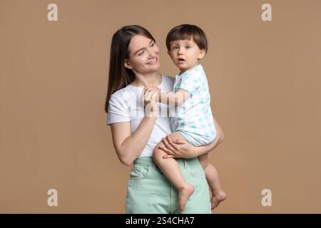 Family portrait of happy mother with her little son on beige background Stock Photo