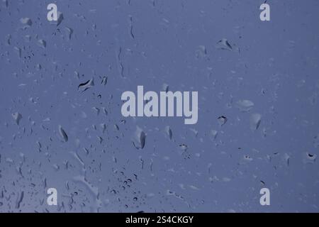 A close-up photo of glass covered with raindrops. Stock Photo
