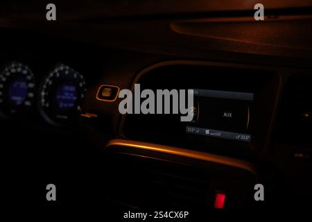 Car interior, control panel of audio player and other devices close-up, automobile dashboard at night, car driving in the dark time of day Stock Photo