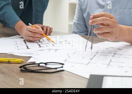 Architects working with project, closeup. Different technical drawings on wooden table Stock Photo
