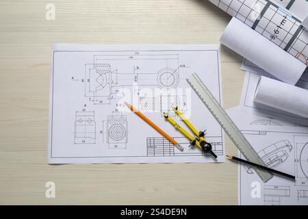 Different engineering drawings, pencils, ruler and divider on wooden table, flat lay Stock Photo