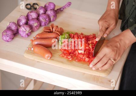 Skillfully Chopping Fresh Vegetables and Sausages in the Kitchen Area Stock Photo