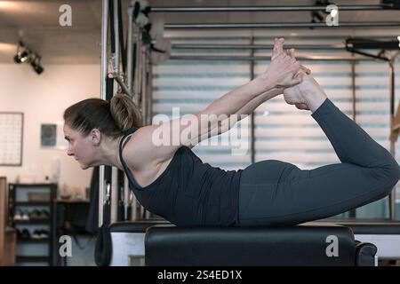 Fit middle age woman doing classic pilates exercises in the gym. Stock Photo
