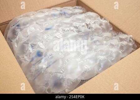 Cushion bubble wrap foil in a opened cardboard box, close up, abstract backdrop Stock Photo
