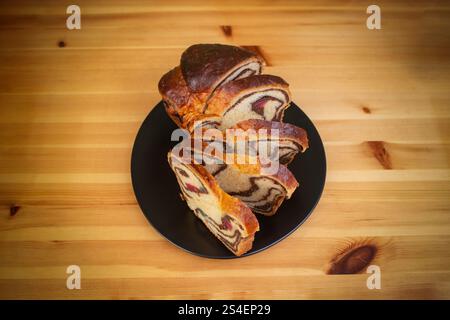 Cozonac, Romanian traditional sweet bread with walnut filling, sliced ,flat lay on a wooden table Stock Photo