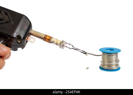 Vintage soldering gun melting coiled wire on white background, soft focus Stock Photo