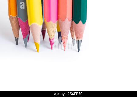 Group of colored crayons writing together on white paper, isolated on white Stock Photo