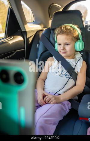 little sitting girl with headphones on white background Stock Photo - Alamy