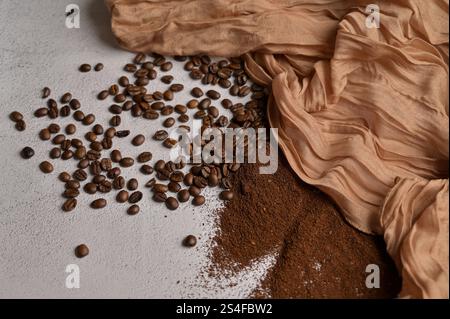 Fresh aromatic grain and ground coffee, white background, brown cloth Stock Photo
