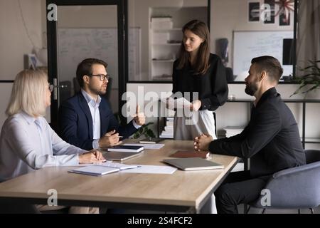 Group of four businesspeople discussing work-related matters Stock Photo