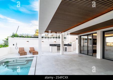 a garden image next to a private swimming pool and outdoor private kitchen in mediterranean villa real estate Stock Photo