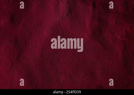 A vibrant burgundy background showcasing a textured and grainy surface, ideal for design projects, posters, and digital content requiring a bold and i Stock Photo