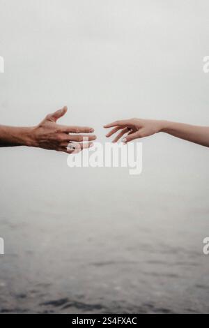 two hands reaching out towards each other Stock Photo