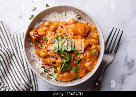 Chicken curry chickpea stew with vegetables in white bowl, white background, top view. Stock Photo