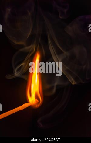 burning match with some smoke on black background Stock Photo
